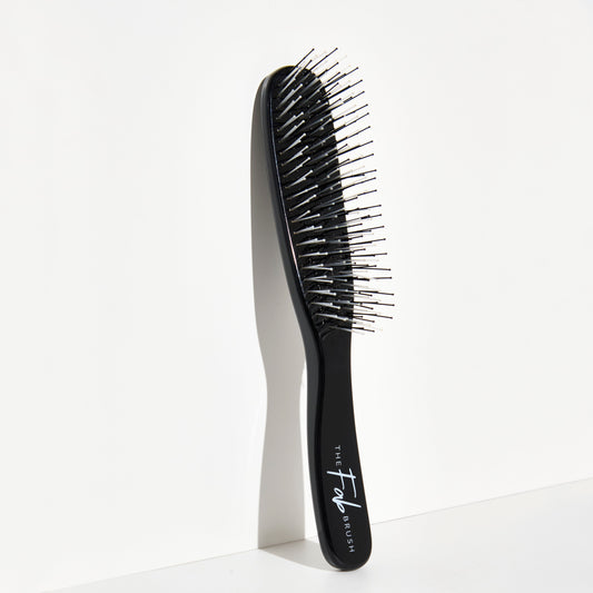 Black hairbrush with 'The Fab Brush' branding on a white background for wet hair brushing